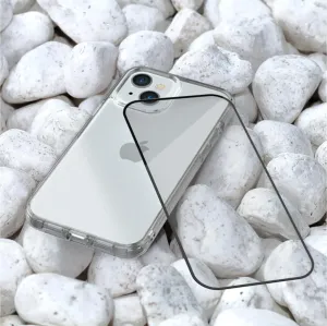 Just Mobile xkin 3D Displayschutz aus gehärtetem Glas für iPhone 15 Plus neben einer transparenten Hülle auf weißen Steinen