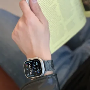 Just Mobile Carbonfaser-Armband an einer Apple Watch, mit schwarzem, strukturiertem Band und sicherem magnetischem Sitz.