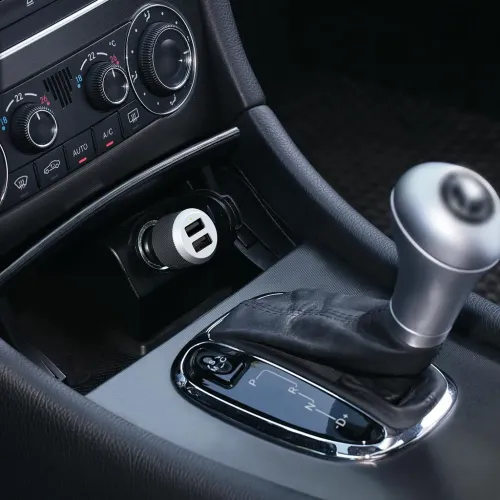 Just Mobile Highway Max billaddare med två USB-portar i bilens 12V-uttag vid mittkonsolen, intill växelspaken och reglagen.