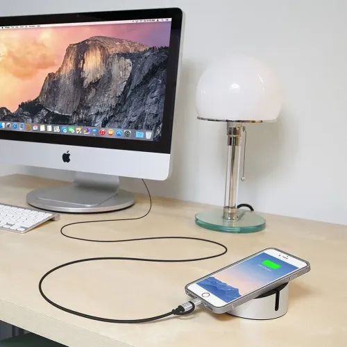 AluCable Duo-Kabel in Schwarz mit Aluminiumsteckern, per Lightning mit einem iPhone auf desktop verbunden und in Richtung Computer gezogen.