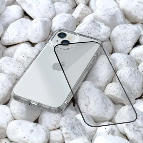 Härdat glas-skärmskydd med rundade hörn och mörk kant, vinklat över en iPhone med genomskinligt skal på små vita stenar.