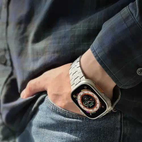 Just Mobile-klockarmband i titan på Apple Watch Ultra, visat på handleden med en design med silverfärgade metallänkar.