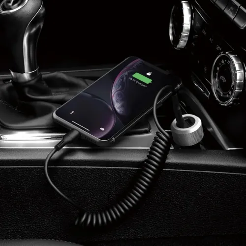 Aluminiumsribbet billader som plugges inn i bilens stikkontakt, med en spiralkabel som lader en smarttelefon på midtkonsollen.